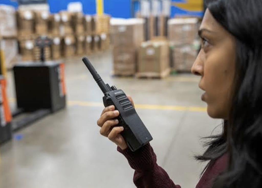 Warehouse worker using DirectPTT radio on manufacturing floor