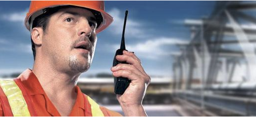 Construction worker using DirectPTT radio on job site